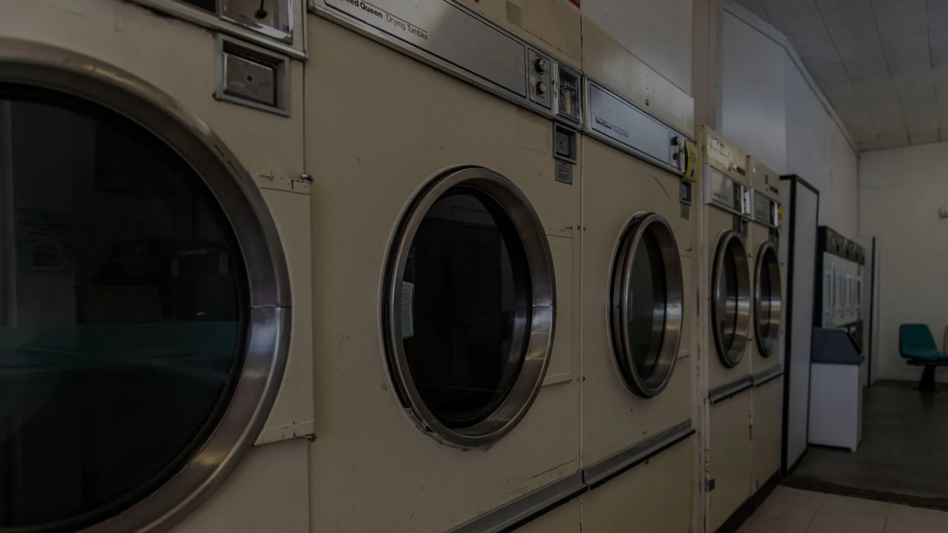 Background image of Sir Sud's Laundromat showing the old dryers before it was renovated